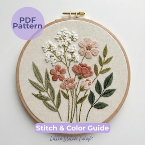 Peut inclure: Un tambour à broder en bois rond contenant un panneau en tissu avec un motif floral. La broderie présente des fleurs blanches, rose poudré et terre cuite avec des feuilles et des tiges vertes. Le texte indique PDF Pattern et Stitch & Color Guide.