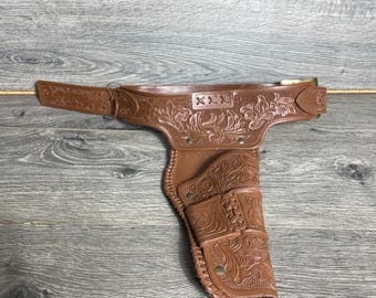 Fondina vintage per pistola giocattolo da cintura in plastica con dettagli retrò e fibbia in metallo, stile western anni '70 e '80.