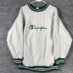 May include: A set of three ceramic mugs with a speckled, matte finish. The mugs are in shades of cream, light gray, and dark gray. Each mug has a simple, minimalist design and a rounded handle.