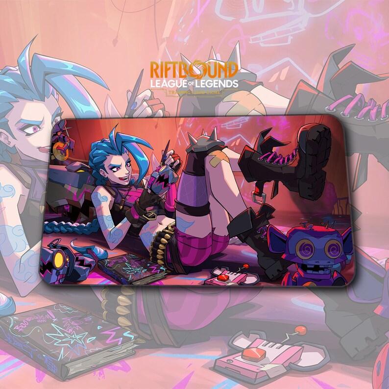 May include: A rectangular mousepad featuring a colorful illustration of a female character with blue hair from the League of Legends game. The character is wearing a pink and black outfit and is surrounded by other game-related elements.