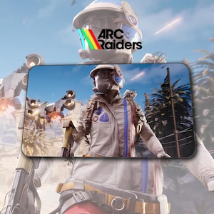 Peut inclure: Tapis de souris de jeu avec un soldat futuriste en combinaison de combat, tenant une arme. Le tapis de souris porte le texte "ARC Raiders" dans un design coloré. L'arrière-plan montre une scène futuriste avec un ciel bleu et des palmiers.