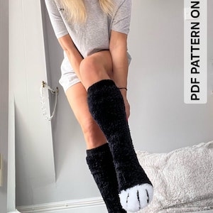 May include: Black knee-high socks with white paw-like designs on the toes. The socks are fluffy and textured. The image also includes the text "PDF PATTERN ONLY".