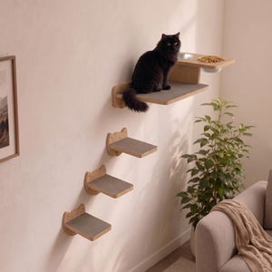 Può includere: Un set di mobili da parete per gatti composto da tre gradini singoli e una piattaforma più grande con due ciotole in metallo integrate. I gradini e la piattaforma in legno presentano superfici in moquette grigia e supporti.