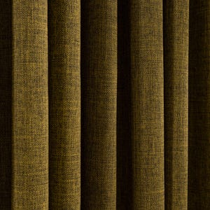 Op de afbeelding: Close-up van olijfgroene gordijnen van textiel. De verticale plooien creëren een patroon van licht en schaduw. De stof heeft een geweven uiterlijk, met subtiele kleurvariaties.