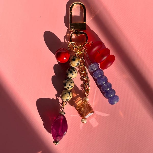 Llavero con dije para bolso / Dije dorado, cuentas de vidrio