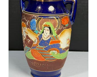 May include: A vintage, hand-painted vase with a dark blue rim and handles. The vase features a brown body with colorful illustrations of figures in traditional attire. Gold accents and floral designs add detail to this decorative piece.