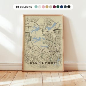 Peut inclure: Une impression encadrée d'une carte de Singapour, avec un plan détaillé des rues et des plans d'eau en beige et bleu. Le mot "SINGAPORE" est affiché en bas. Le haut du cadre indique "10 COULEURS" avec des options de couleurs.