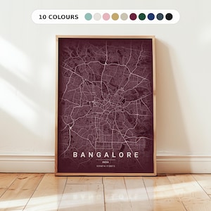 May include: A framed map print of Bangalore, India, in a deep burgundy hue. The city's road network is depicted in white lines. The text "BANGALORE INDIA" is at the bottom. The top of the frame has a colour palette with the text "10 COLOURS".