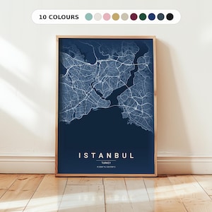 Puede incluir: Un póster enmarcado con un mapa detallado de Estambul en tonos azules y blancos. El nombre de la ciudad se muestra en letras mayúsculas blancas en la parte inferior, con el país y las coordenadas debajo. El marco es de color madera clara y la imagen está etiquetada como "10 COLOURS" en la parte superior.