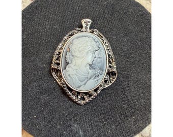 Colgante camafeo vintage con retrato de mujer y marco de diamantes de imitación en tono plateado.