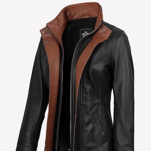 May include: A black leather jacket with a brown collar and interior lining. The jacket has a zipper closure, a small pocket, and a tailored fit. The jacket is designed for outerwear.