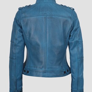 May include: A blue leather jacket with a stand-up collar, shoulder epaulets, and buttoned cuffs. The jacket has a tailored fit, with a buttoned waist and multiple pockets. The leather has a distressed appearance.