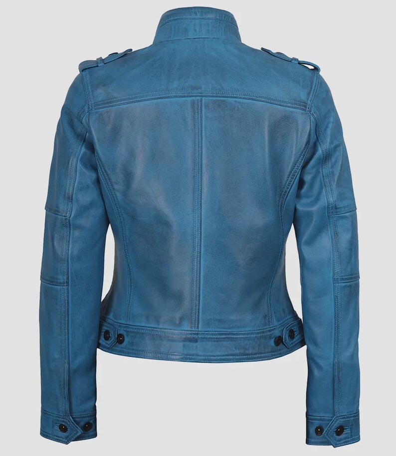 May include: A blue leather jacket with a stand-up collar, shoulder epaulets, and buttoned cuffs. The jacket has a tailored fit, with a buttoned waist and multiple pockets. The leather has a distressed appearance.