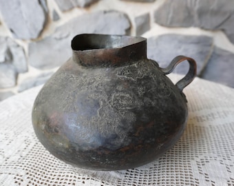 Antique copper pitcher that has withstood decades of use with an unsurpassable  character.