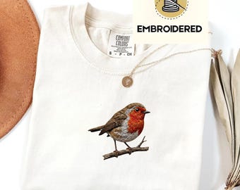 Embroidered robin bird shirt featuring a small red-breasted bird perched on a branch in a minimal nature-inspired design.