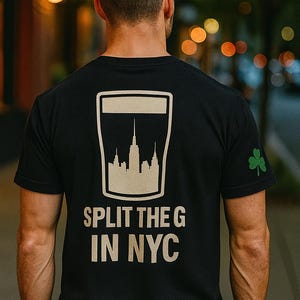 May include: Black t-shirt featuring a white graphic of the New York City skyline within a beer glass shape. The text "SPLIT THE G IN NYC" is below the graphic. A green shamrock is on the sleeve.