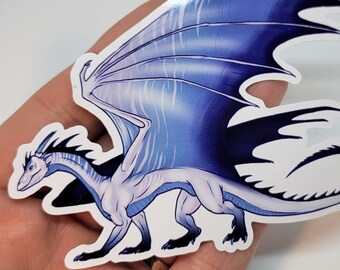 Könnte beinhalten: Ein weißer und blauer Drachenaufkleber mit ausgebreiteten Flügeln. Der Drache hat einen langen Schwanz und eine spitze Schnauze. Der Aufkleber befindet sich auf einem weißen Hintergrund.