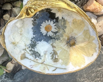 Plato grande con forma de concha decorado con flores secas.