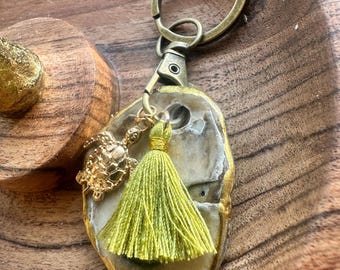 Llavero de ostra con borla verde y dije de tortuga