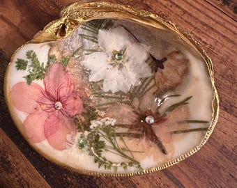 Plato de joyería de concha con flores secas