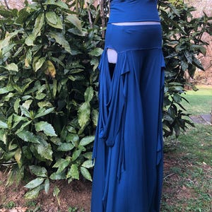 May include: A two-piece outfit in a deep blue hue. The top is a fitted tank, and the bottom is a flowing skirt with draped fabric details. The outfit is made of a soft, flowing material, perfect for a special occasion or a unique style statement.