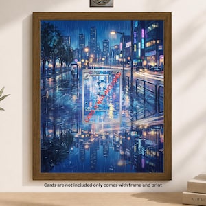 May include: A framed print of a rainy city street scene at night, with reflections in the wet pavement. The artwork features a trading card with a cartoon character. The frame is brown, and the print is displayed on a white wall.