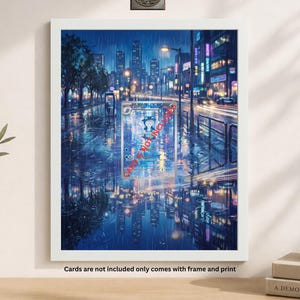 May include: A framed print featuring a rainy cityscape at night, with reflections on wet streets. The artwork has a vibrant color palette of blues, purples, and yellows. The frame is white. Text on the print reads "NOTINCI". The text at the bottom says "Cards are not included only comes with frame and print".