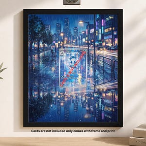May include: Framed print of a rainy city street scene at night, with reflections in the wet pavement. The artwork features a trading card in the center. The frame is black. The text at the bottom says "Cards are not included only comes with frame and print."