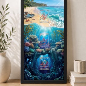 以下が含まれることがあります： ビーチと水中サンゴ礁のシーンを描いた額装アートワーク。3つのトレーディングカード表示エリアがあります。黒いフレームには「Cards are not included only comes with frame and print」と書かれています。
