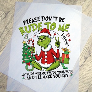 May include: A Christmas-themed graphic featuring the Grinch in a Santa suit, holding a candy cane and a Christmas tree. Text reads "PLEASE DON'T BE RUDE TO ME because MY RUDE WILL OUTRUDE YOUR RUDE AND I'LL MAKE YOU CRY."