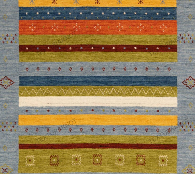 May include: A rectangular area rug with a light blue background and horizontal stripes in various colors. The stripes include orange, green, yellow, and dark blue, with decorative patterns. The rug has a textured appearance.