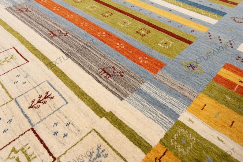 May include: A colorful area rug with a geometric pattern. The rug features stripes in various colors, including orange, blue, green, and yellow. The design incorporates squares and rectangles with decorative motifs. The rug is made of a woven material.