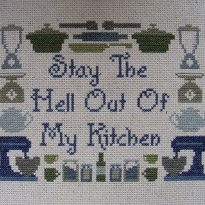 May include: Cross-stitch embroidery with a kitchen theme. The design features a kitchen mixer, teapots, and a message that reads "Stay the Hell Out of My Kitchen".