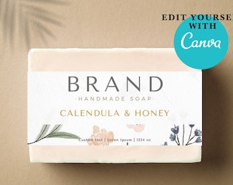 May include: A bar of handmade soap with a white label that reads "BRAND HANDMADE SOAP CALENDULA & HONEY Custom text | Lorem Ipsum | 1234 oz". The label has a floral design with green leaves and pink and blue flowers.