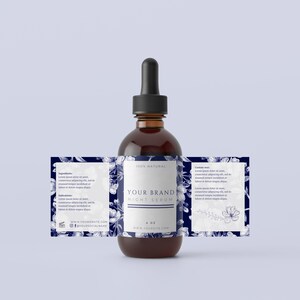 May include: A brown glass bottle with a dropper top and a white label that says "100% NATURAL YOUR BRAND NIGHT SERUM 1 OZ WWW.YOURSITE.COM" The label has a blue floral design.