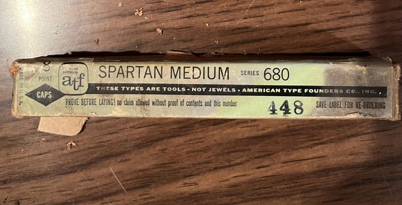 May include: A rectangular box labeled "SPARTAN MEDIUM SERIES 680" with the text "THESE TYPES ARE TOOLS - NOT JEWELS." The box is light green and beige with black text. The box also has the text "AMERICAN TYPE FOUNDERS CO., INC."