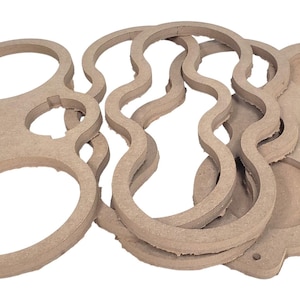 May include: A collection of unfinished, light brown wooden cutouts in various shapes. The shapes include a figure eight with holes, wavy lines, and a tray with circular cutouts. These craft supplies are ready for painting or other customization.