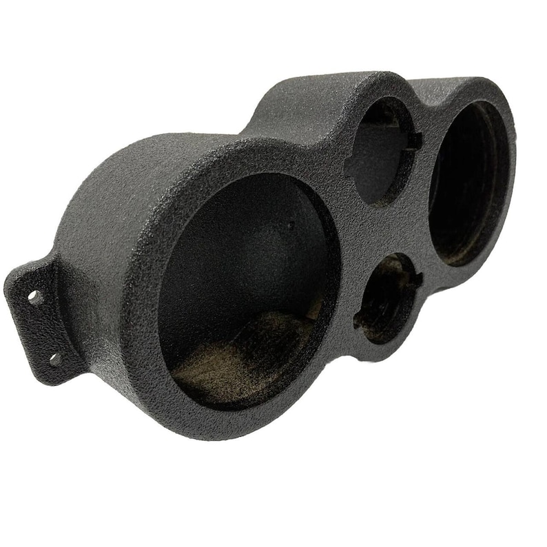 May include: A black, textured gauge pod with three circular openings of varying sizes. The pod has a rounded shape with a mounting bracket on the left side. The openings are designed to hold gauges.