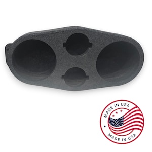 May include: Black foam car audio speaker enclosure with two large and two smaller circular openings. The product is made in the USA, as indicated by the red, white, and blue emblem.