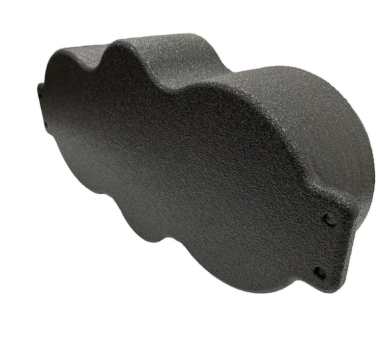 May include: A textured, dark gray object with a unique, cloud-like shape. The object has a rounded, cylindrical end and a series of curved indentations along its side. The surface appears to be matte and non-reflective.