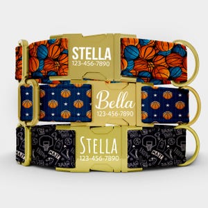 May include: Three dog collars with gold-colored buckles. The top collar has a pattern of orange and blue basketballs. The middle collar has a navy blue background with orange basketballs. The bottom collar has a black background with basketball-themed graphics. Each collar has a name and phone number.