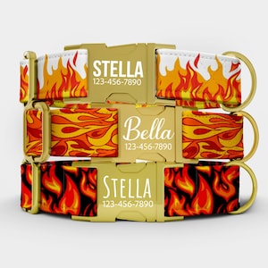 May include: Three personalized dog collars with gold-colored buckles and D-rings. The collars feature a flame pattern in red, orange, and yellow. Each collar has a name and phone number printed on the buckle: Stella and Bella.