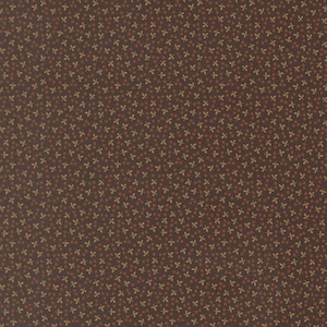 May include: A dark brown fabric featuring a repeating pattern of small, light tan leaf clusters interspersed with tiny, evenly spaced rust-colored dots. The textile displays a consistent, dense, and uniform print across the entire surface area.