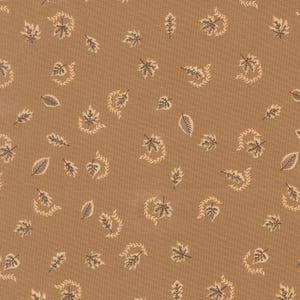 May include: A tan fabric featuring a repeating pattern of small, dark brown leaves and delicate, curved vine-like sprigs scattered across the surface. The textile has a visible woven texture with a consistent, neutral earth-toned background colour.