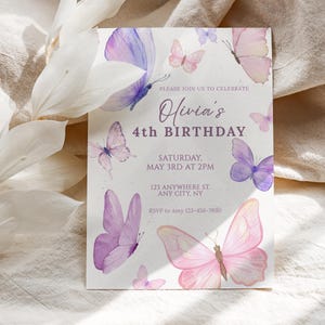 May include: A birthday invitation featuring watercolor butterflies in shades of pink and purple. The text reads "Olivia's 4th Birthday" with event details. The design includes delicate butterfly illustrations scattered around the edges.