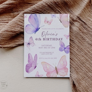 May include: A rectangular invitation card with watercolor butterflies in shades of purple and pink. The text reads "Olivia's 4th Birthday" with event details. The card is set against a textured, neutral-toned fabric.
