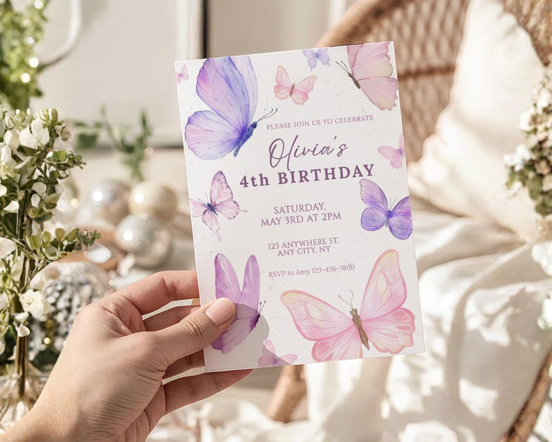 May include: A white invitation card featuring watercolor butterflies in shades of pink and purple. The text reads "Olivia's 4th Birthday" with event details. The card is held by a hand.