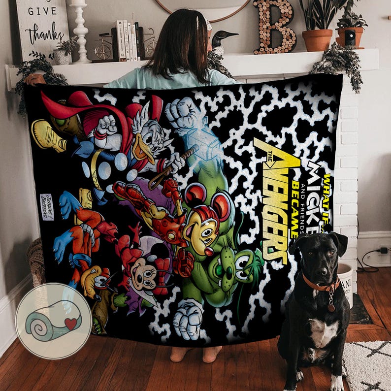 Puede incluir: Una manta negra con un colorido collage de dibujos animados de los Vengadores de Marvel y personajes de Disney, incluyendo a Mickey Mouse, Thor y el Pato Donald. La manta tiene un patr&oacute;n de manchas blancas y negras y el texto "The Avengers" y "Mickey and Friends".
