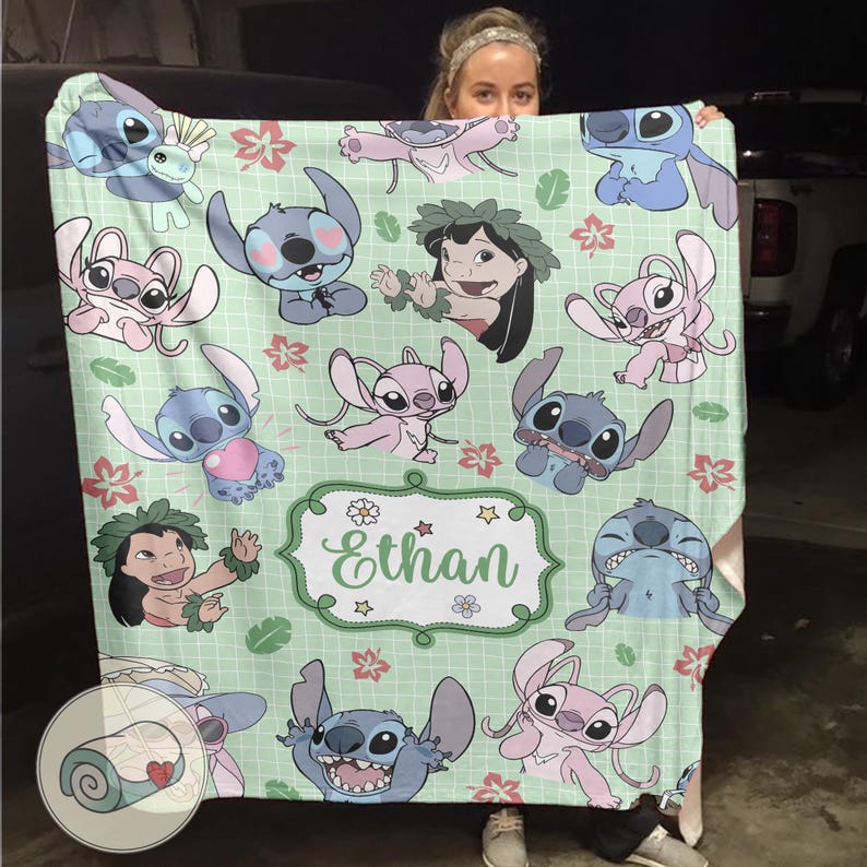 Puede incluir: Una manta verde claro con personajes de dibujos animados, incluyendo Stitch y Lilo, con un nombre personalizado, Ethan, en un marco decorativo. La manta tiene un patr&oacute;n repetido de los personajes y acentos florales.