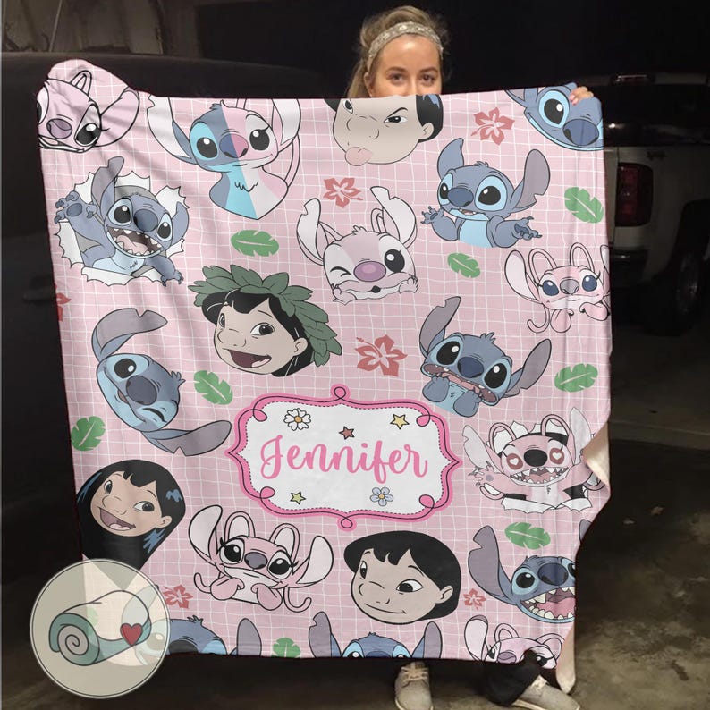 May include: Pink blanket featuring various cartoon character illustrations, including Stitch and Lilo. The blanket has a grid pattern and a decorative frame with the name "Jennifer".